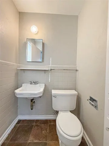a view of an empty room with wooden floor and a ceiling fan