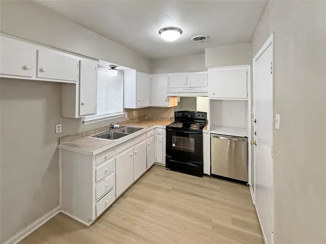 a kitchen with white cabinets appliances and sink