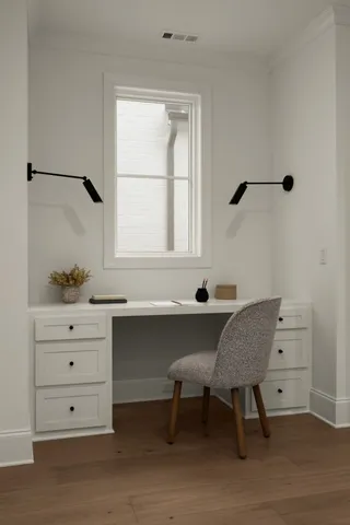 a view of a workspace with furniture and a window