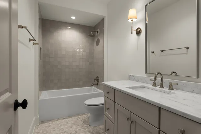 a bathroom with a granite countertop sink a toilet and shower