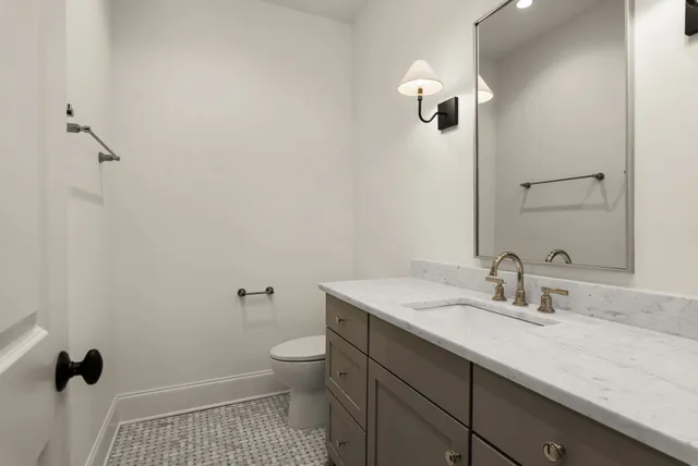 a bathroom with a sink a toilet and a mirror