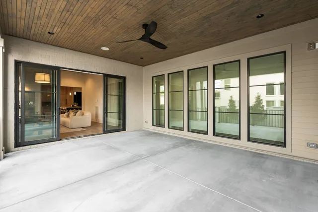 a large room with large windows and a ceiling fan