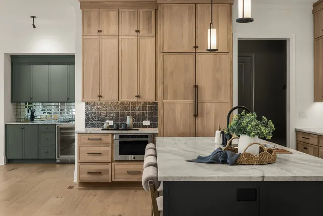 a kitchen with kitchen island granite countertop a sink cabinets and stainless steel appliances