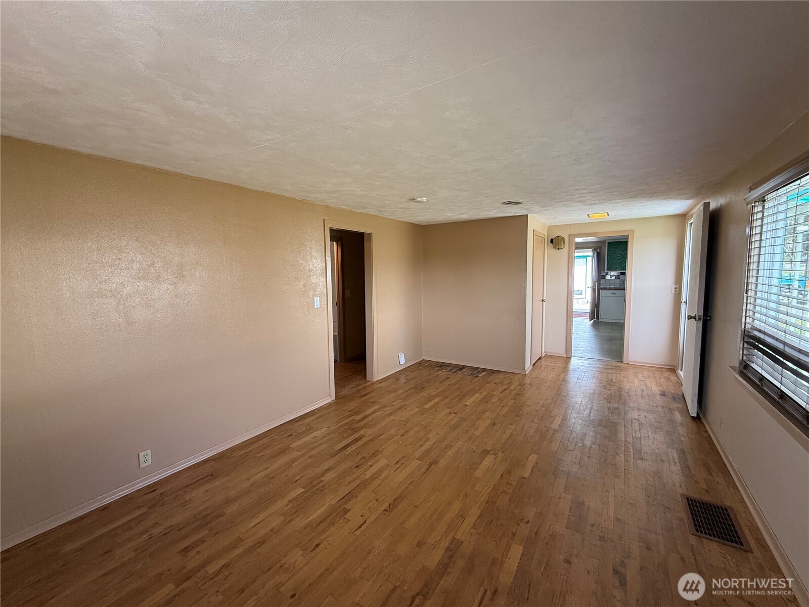 306 South Adams Street Waterville, WA 98858 - Photo 4 of 25 a view of empty room with wooden floor and fireplace
