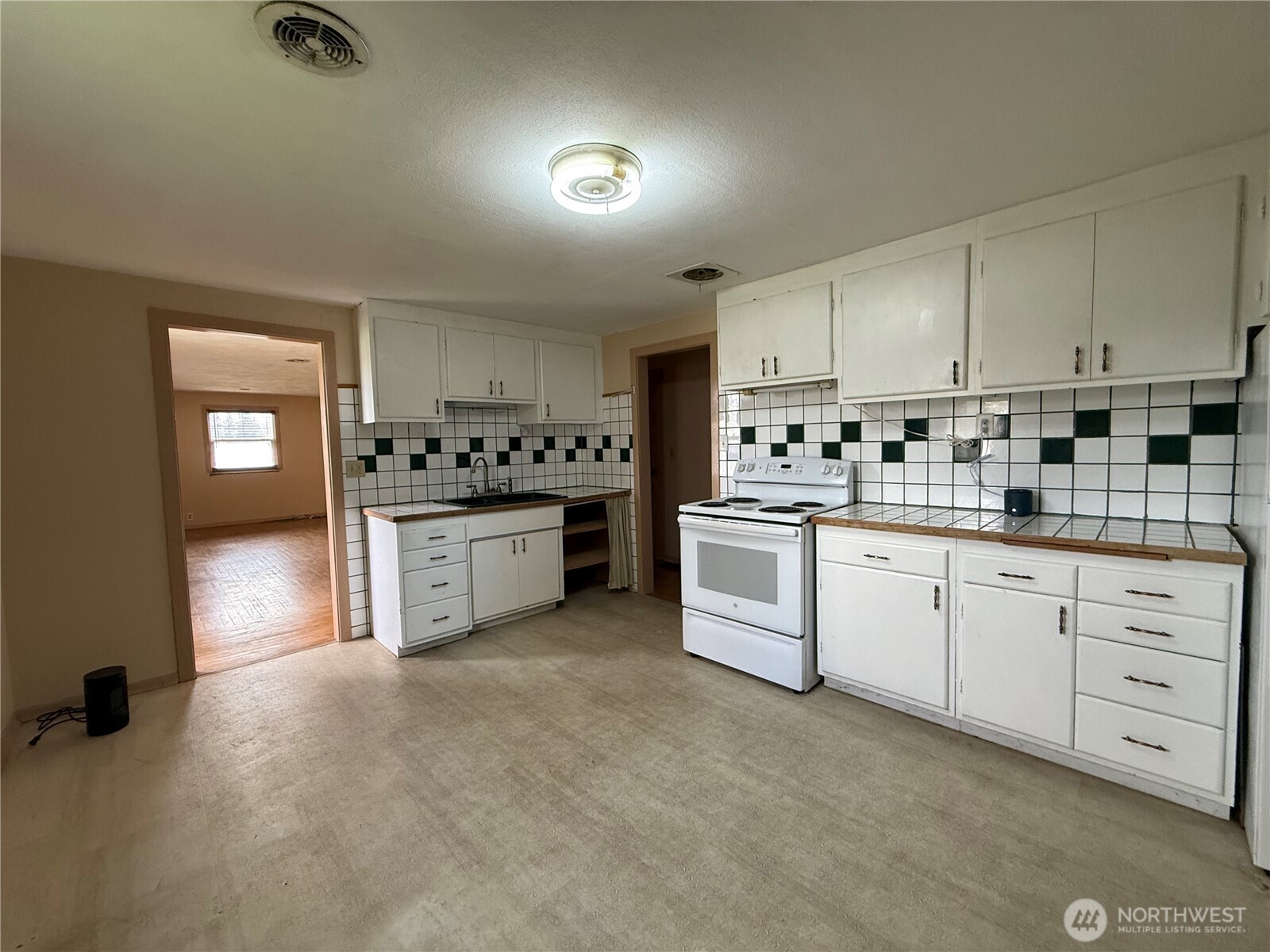 306 South Adams Street Waterville, WA 98858 - Photo 5 of 25 a kitchen with white cabinets and white appliances