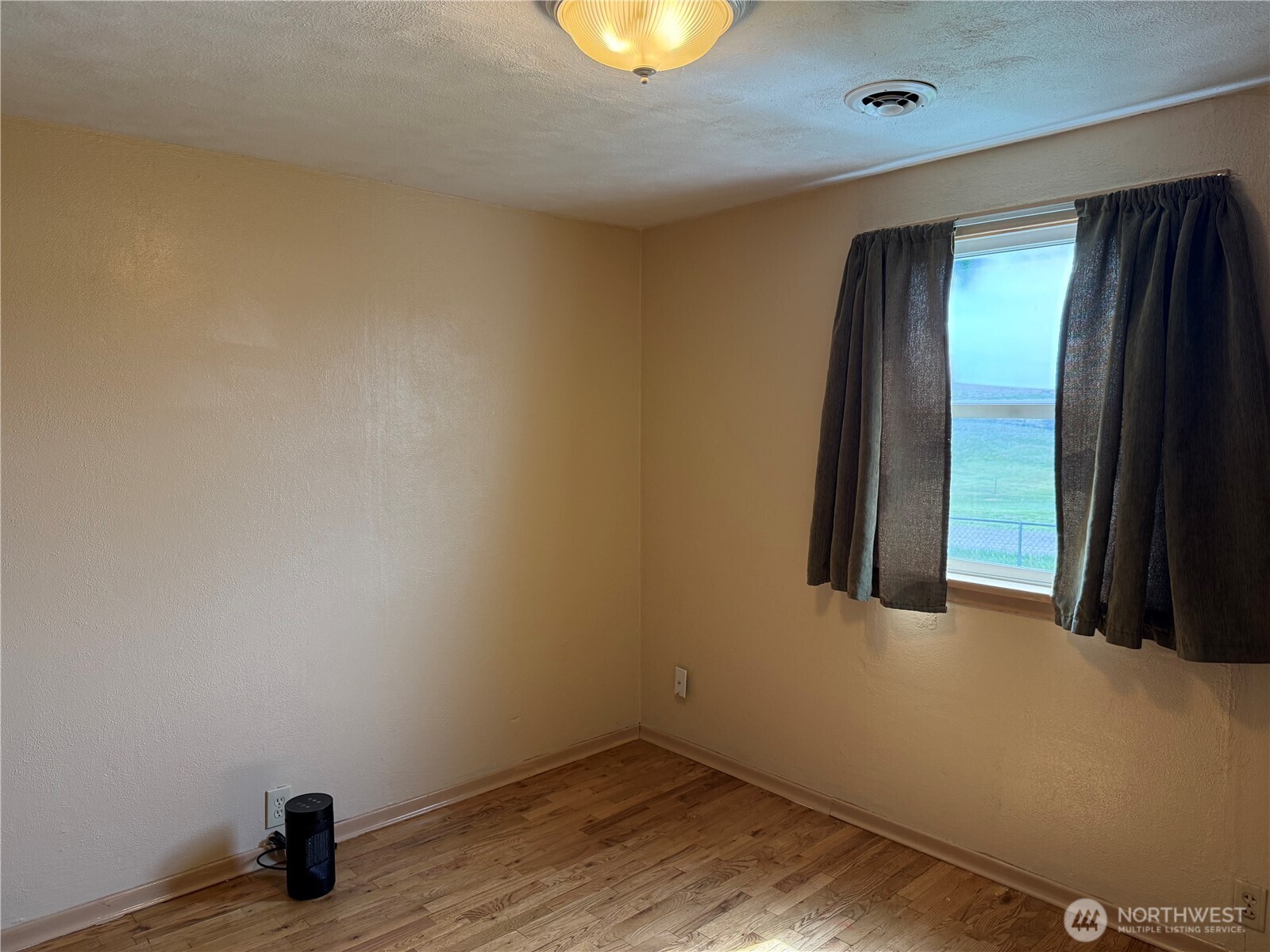 306 South Adams Street Waterville, WA 98858 - Photo 10 of 25 an empty room with wooden floor and windows