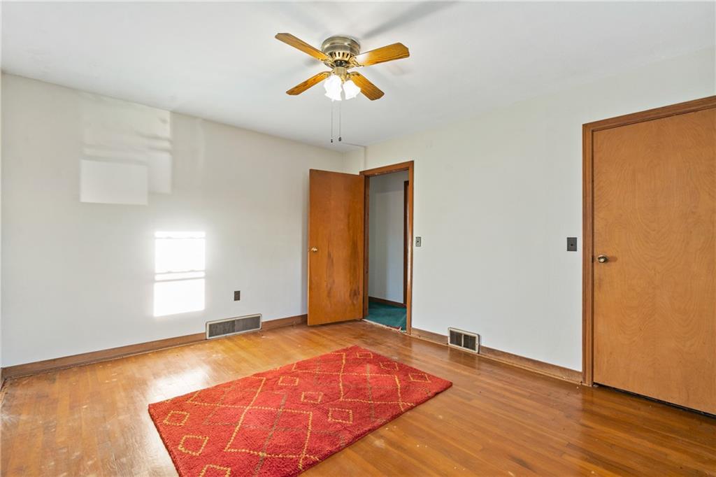223 Oak Road Pittsburgh, PA 15239 - Photo 13 of 25 an empty room with wooden floor and a chandelier fan