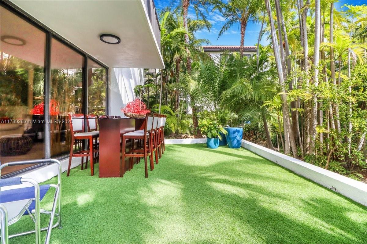 101 Ocean Ln Drive, Unit 1017 Key Biscayne, FL 33149 - Photo 20 of 25 a backyard of a house with table and chairs