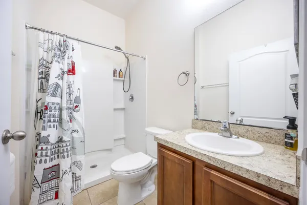 a bathroom with a granite countertop sink toilet and shower