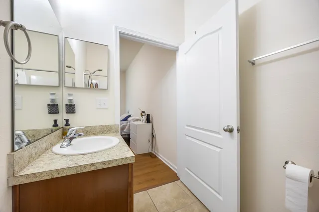 a bathroom with a granite countertop sink and a mirror