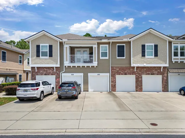 a view of a house with a barbeque and large trees