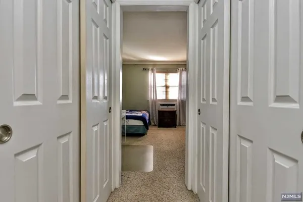 a view of a hallway with a livingroom and a bathroom