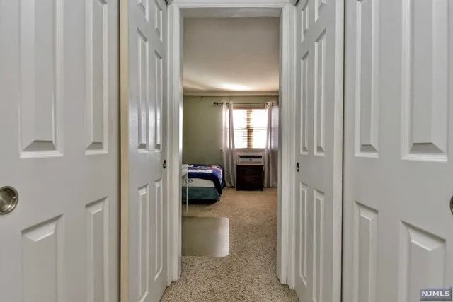a view of a hallway with a livingroom and a bathroom