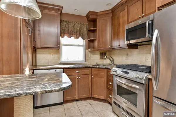 a kitchen with granite countertop stainless steel appliances a stove sink and microwave