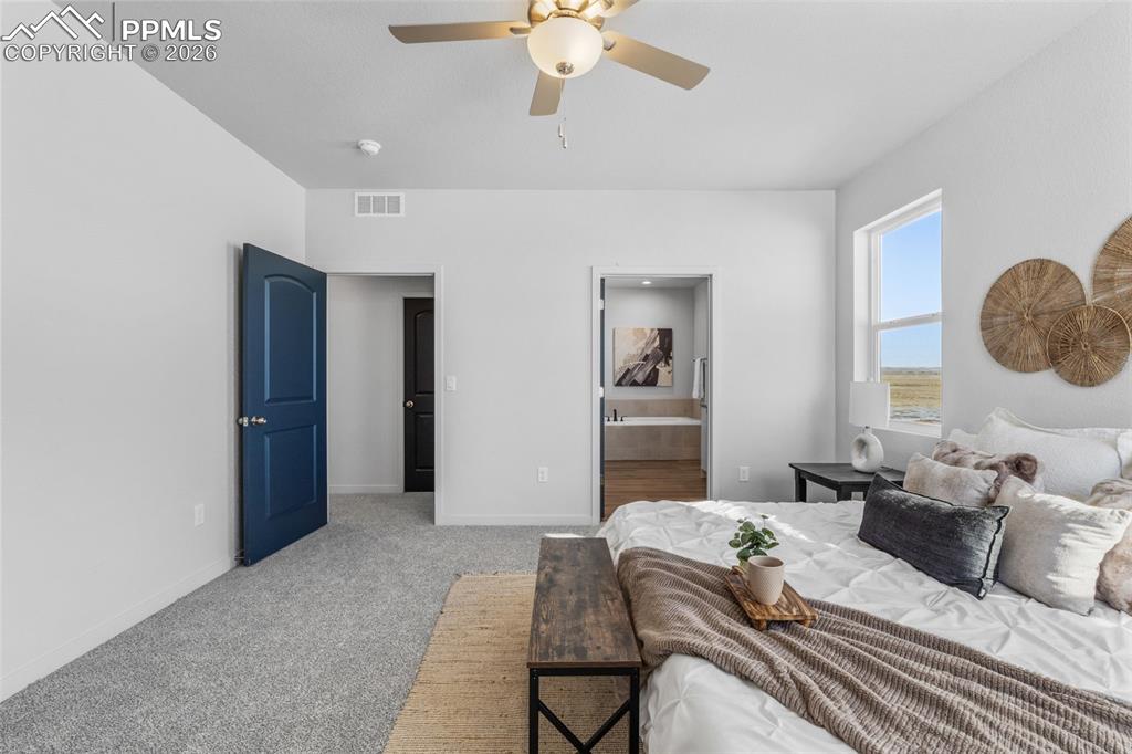 24515 Big Springs Road Calhan, CO 80808 - Photo 17 of 46 a bedroom with a bed and a chandelier