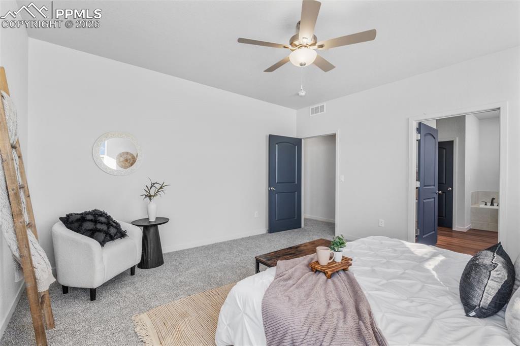 24515 Big Springs Road Calhan, CO 80808 - Photo 18 of 46 a bedroom with a bed and a chandelier