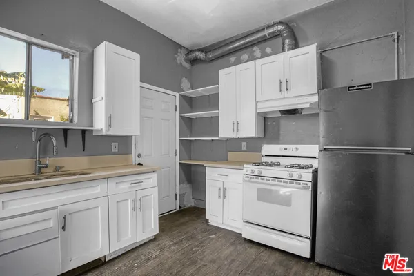 a kitchen with white cabinets and white appliances
