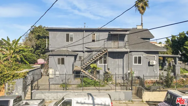 an aerial view of residential house with parking space and mountain view in back