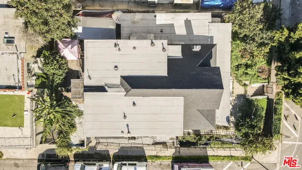 an aerial view of residential houses with outdoor space and trees