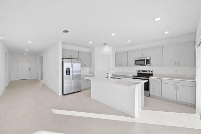 a kitchen with a sink stainless steel appliances and white cabinets