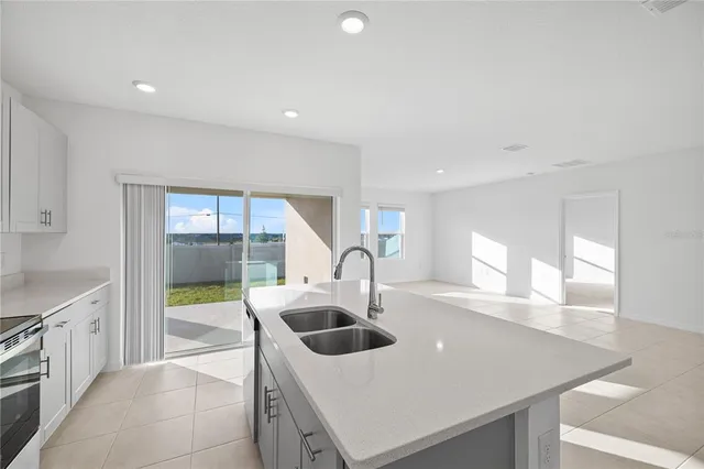 a kitchen with a sink a microwave a stove and cabinets