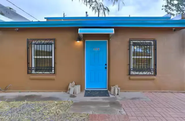a view of backyard with table and chairs under an umbrella