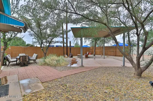 a backyard of a house with trampoline fire pit and iron fence