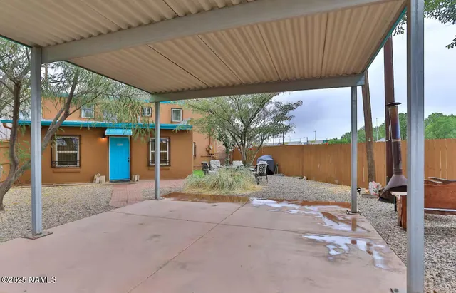 a view of backyard with table and chairs under an umbrella