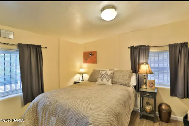 a bedroom with a bed and wooden floor