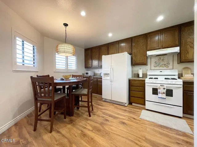 a kitchen with refrigerator cabinets dining table and chairs