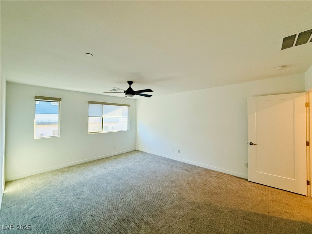 3219 Timorasso Avenue Henderson, NV 89044 - Photo 14 of 27 Empty room featuring light colored carpet and ceiling fan