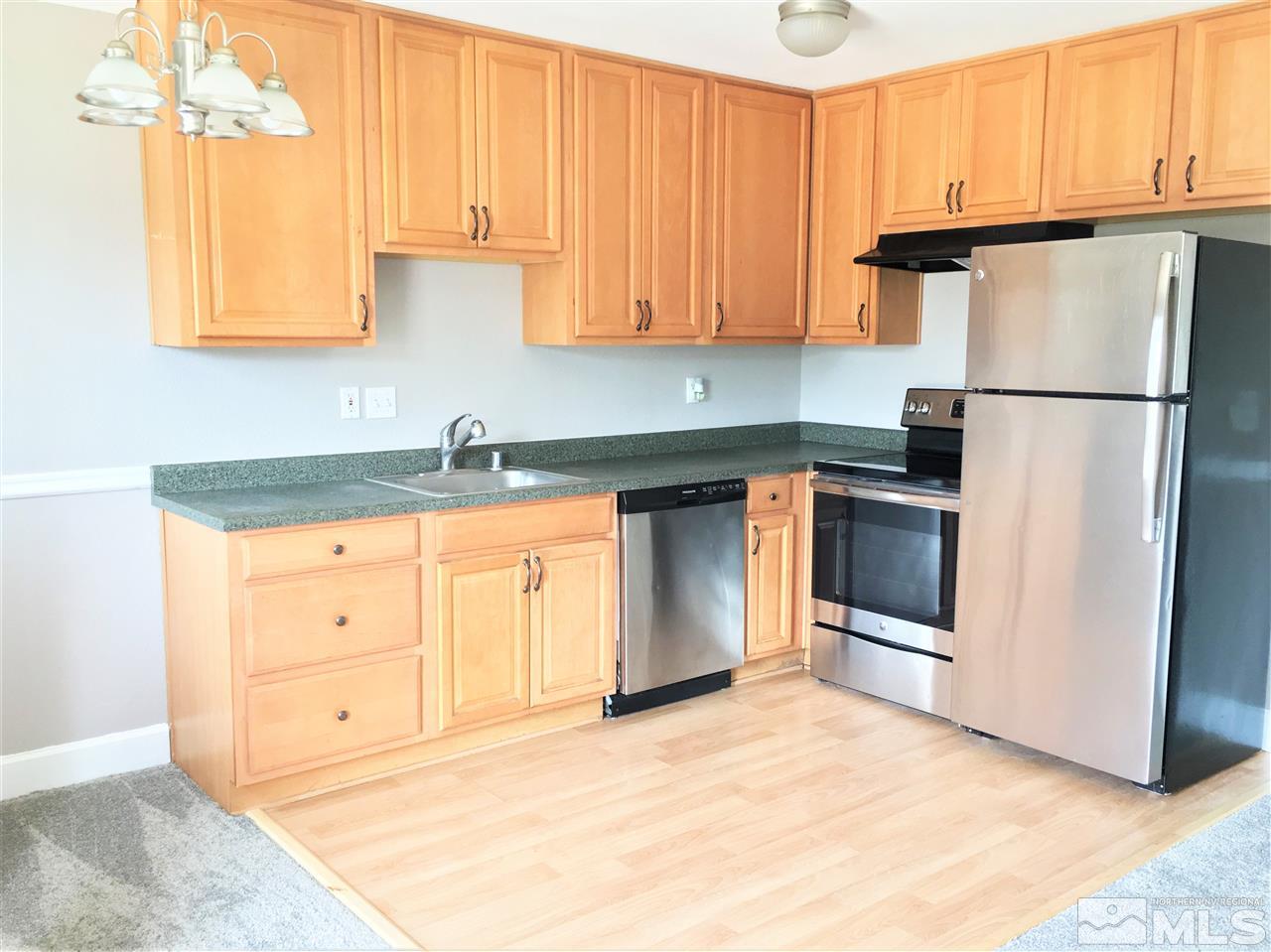 197 East Grove Street, Unit E8 Reno, NV 89502 - Photo 3 of 10 a kitchen with granite countertop a refrigerator sink and cabinets