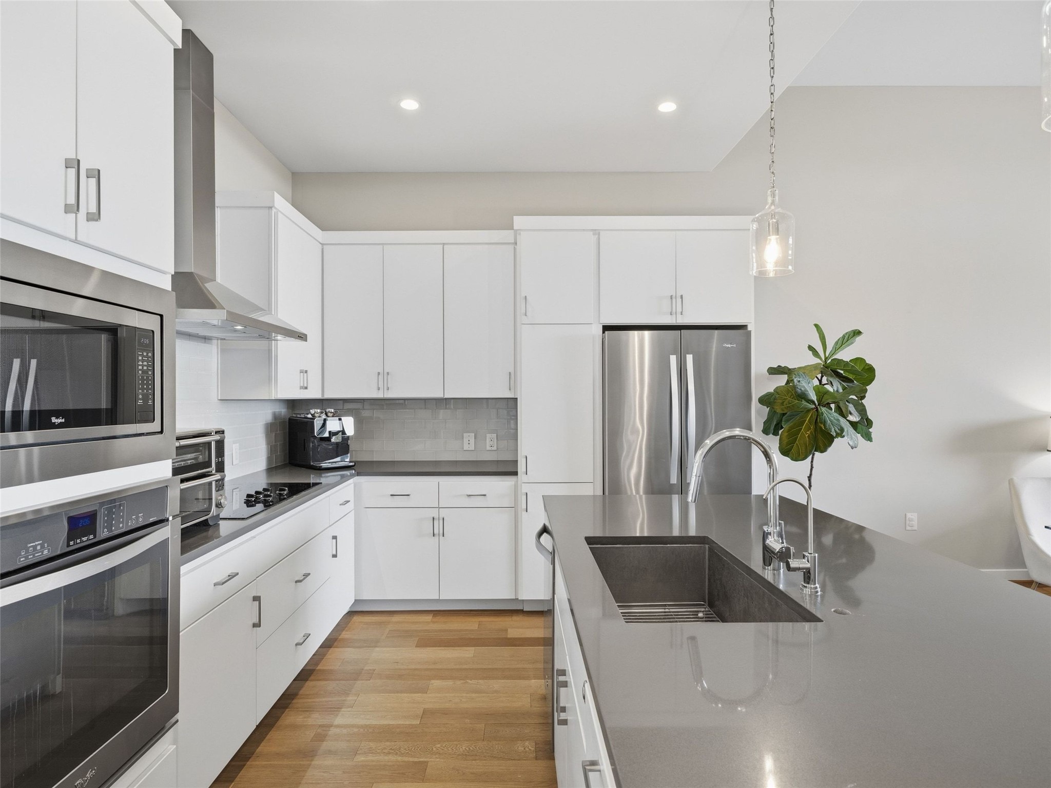 5921 Hiline Road, Unit 1303 Austin, TX 78734 - Photo 8 of 37 a kitchen with a sink dishwasher a refrigerator and white cabinets with wooden floor