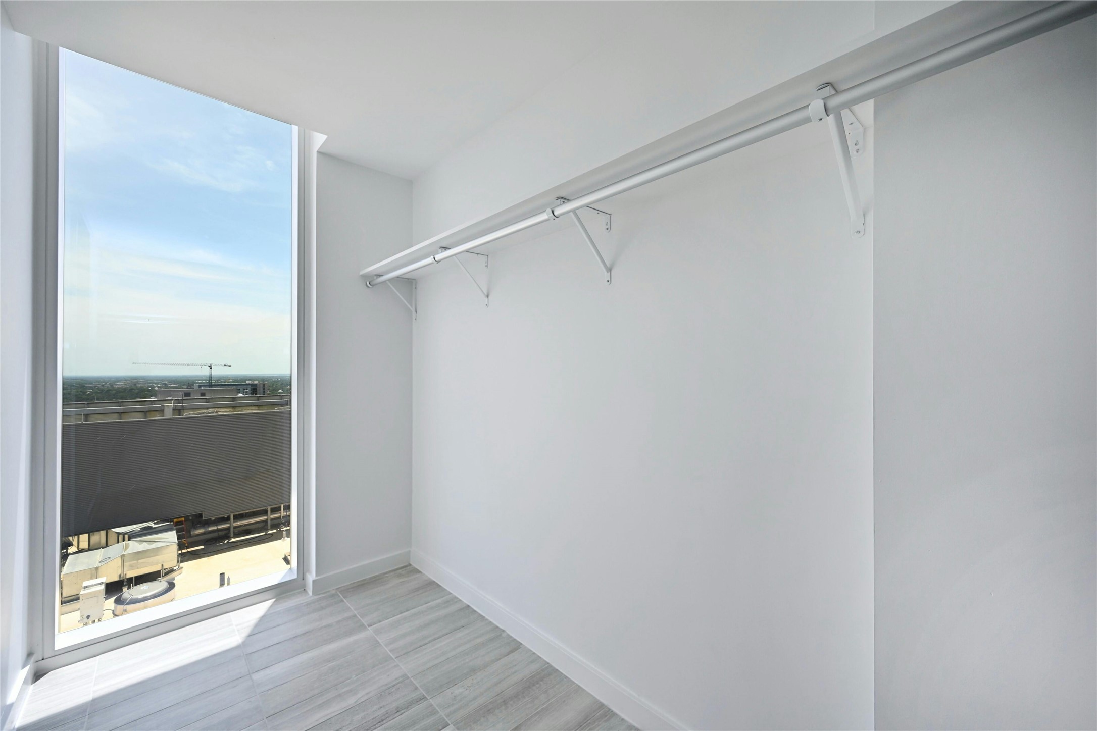313 West 17th Street, Unit 2101 Austin, TX 78701 - Photo 14 of 36 Bright and spacious walk-in closet with floor-to-ceiling window, offering natural light and skyline views—perfect for a stylish start to the day.