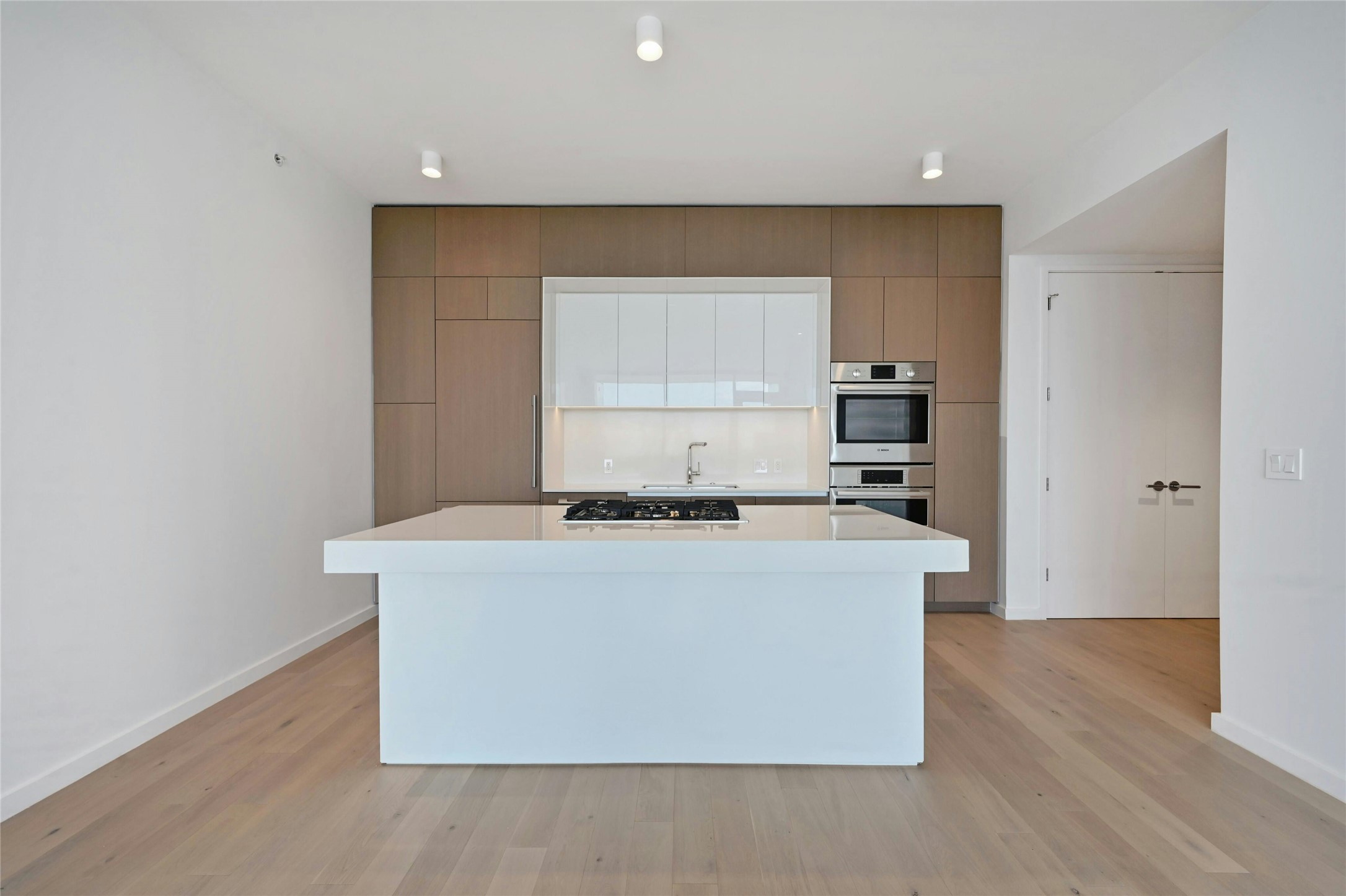 313 West 17th Street, Unit 2101 Austin, TX 78701 - Photo 4 of 36 A streamlined culinary space highlighted by Bosch appliances, a gas cooktop built into the expansive quartz island, and custom cabinetry that seamlessly conceals the refrigerator and dishwasher for a clean, modern aesthetic.