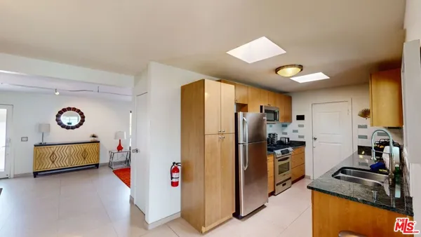 a kitchen with stainless steel appliances granite countertop a refrigerator and a stove