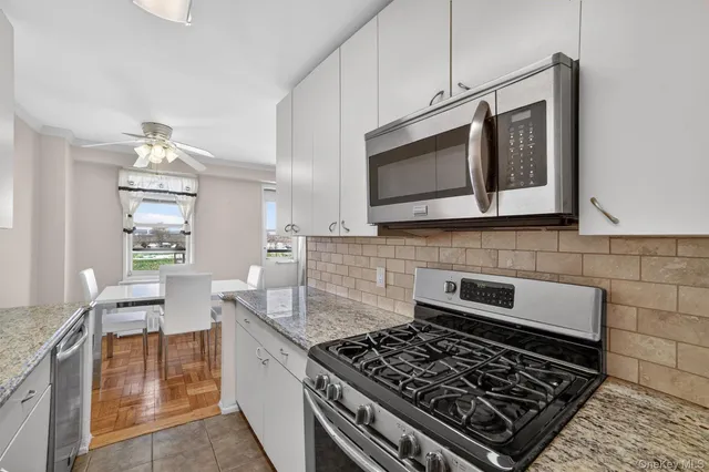a kitchen with stainless steel appliances granite countertop a stove and a microwave
