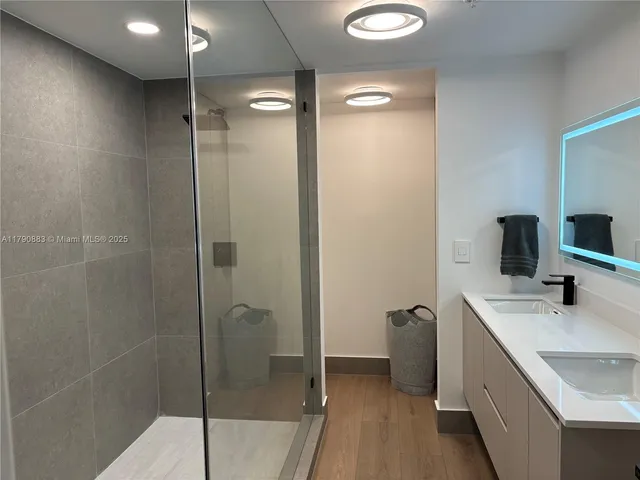 a bathroom with a shower sink and mirror