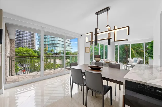 a dining room with wooden floor a chandelier and a flat screen tv