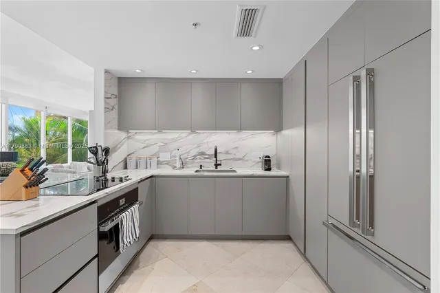 a kitchen with stainless steel appliances a sink and a refrigerator