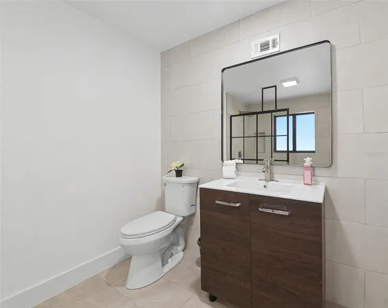 a bathroom with a toilet a sink and mirror