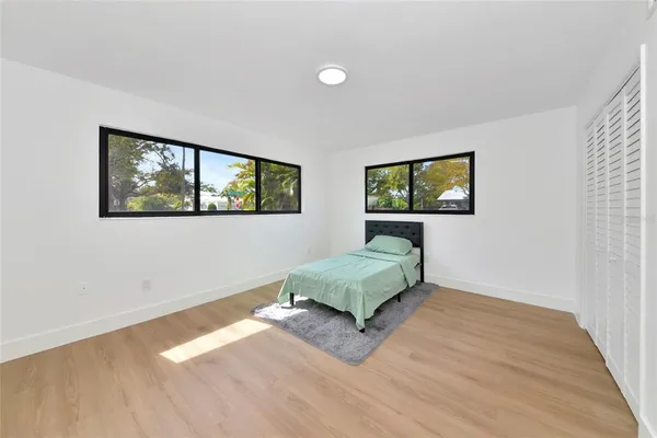 a living room with a bed furniture and two windows