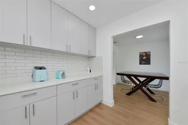 a kitchen with a sink a table and chairs in it