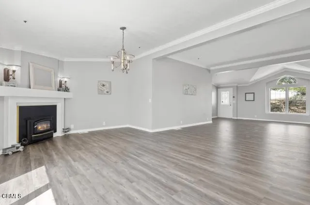 a view of a livingroom with wooden floor a fireplace and windows