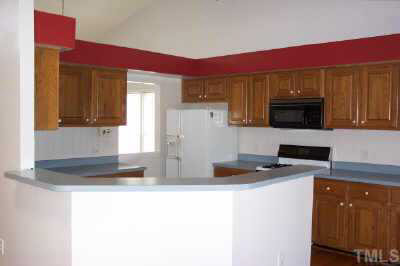 8401 Waynesboro Court Raleigh, NC 27615 - Photo 3 of 10 a kitchen with stainless steel appliances granite countertop a stove a sink and a microwave