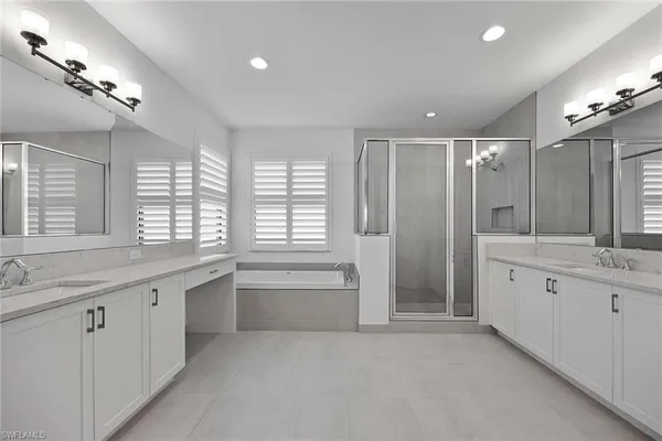 a bathroom with a granite countertop sink mirror and a bathtub
