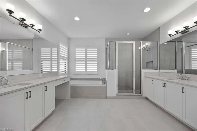 a bathroom with a granite countertop sink mirror and a bathtub