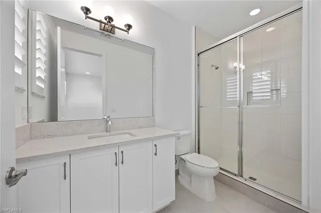 a bathroom with a granite countertop sink toilet a mirror and shower