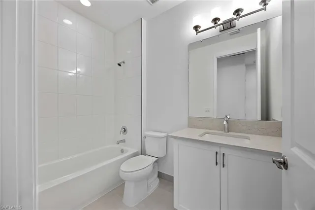 a bathroom with a granite countertop sink a toilet and shower