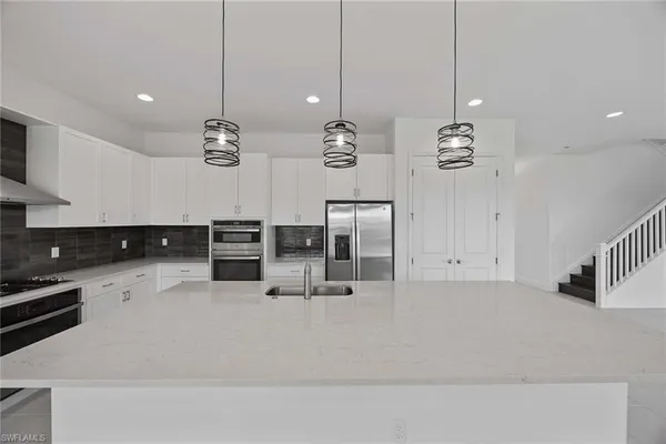 a kitchen with stainless steel appliances kitchen island granite countertop a table and chairs in it